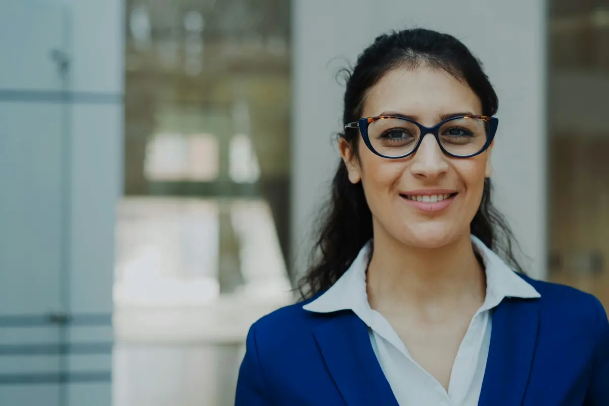 Portrait d'une responsable souriante en tailleur bleu dans un bureau moderne