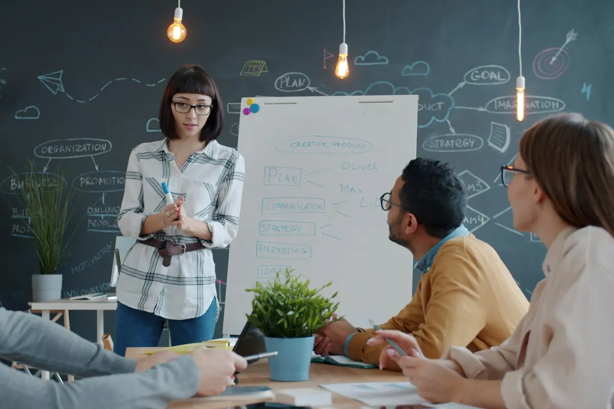 Woman presenting at a whiteboard to her team during a workshop